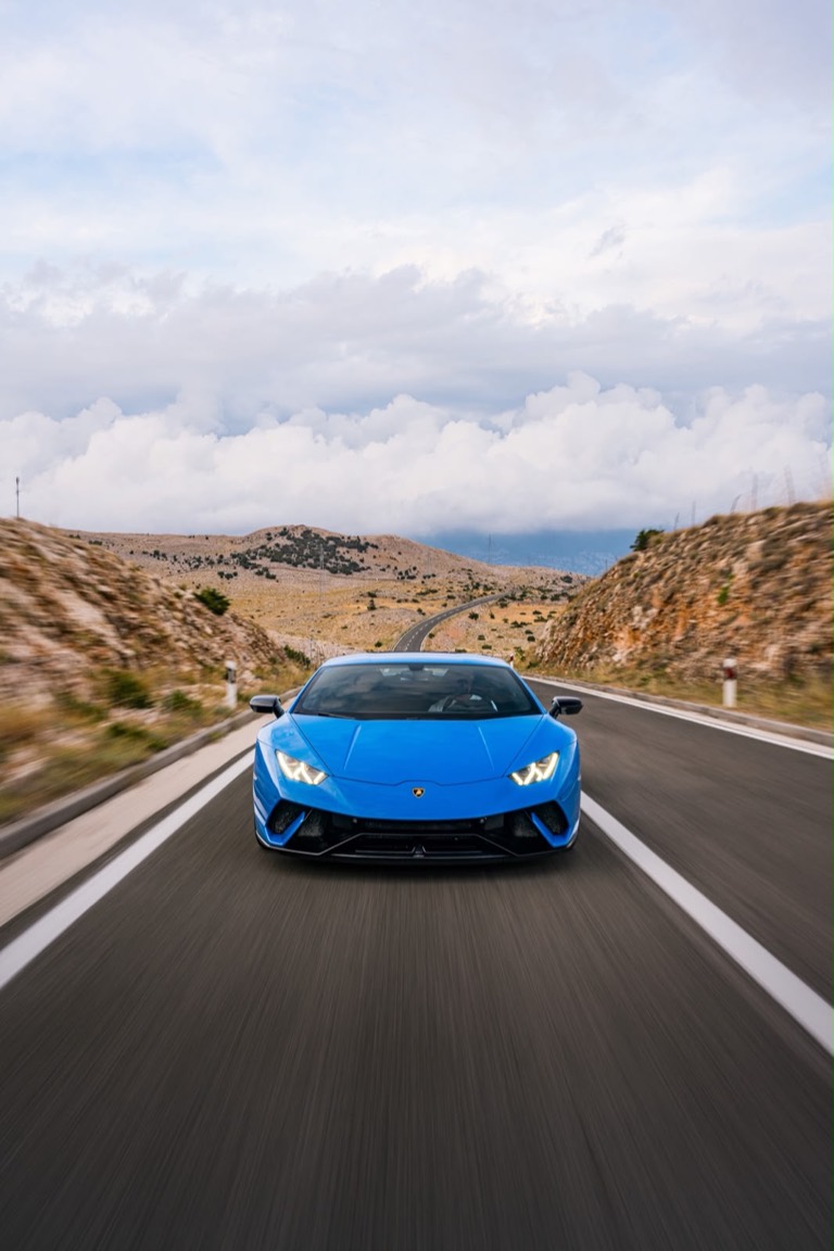 Blue Huracan Performante head on, at speed on a mountain road.